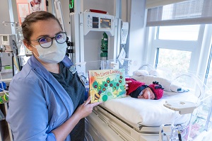 护士拿着书，婴儿打扮成瓢虫